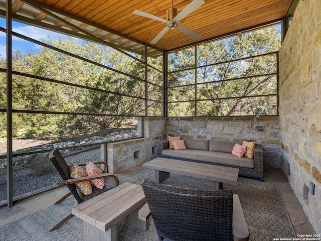 sunroom featuring ceiling fan and an outdoor living space