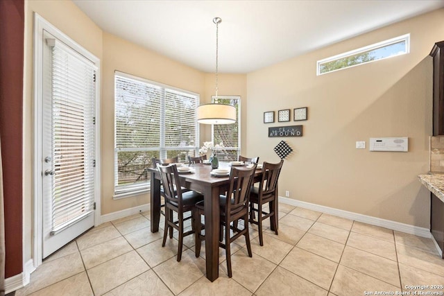 dining space featuring light tile patterned floors, baseboards, and a healthy amount of sunlight