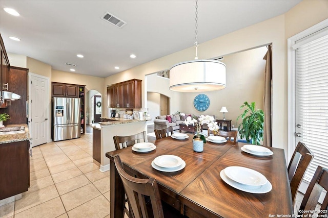 dining area featuring visible vents, arched walkways, light tile patterned floors, and recessed lighting
