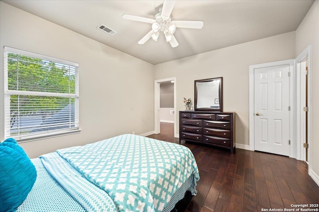 bedroom with baseboards, ceiling fan, dark wood-type flooring, and visible vents