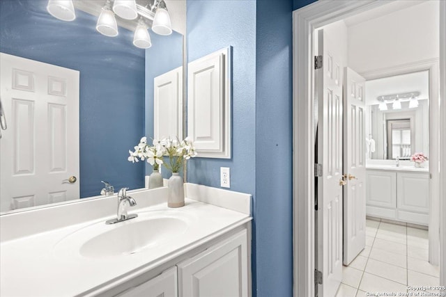 bathroom with vanity, tile patterned flooring, and a textured wall