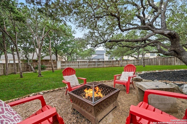 view of yard featuring a fenced backyard and a fire pit