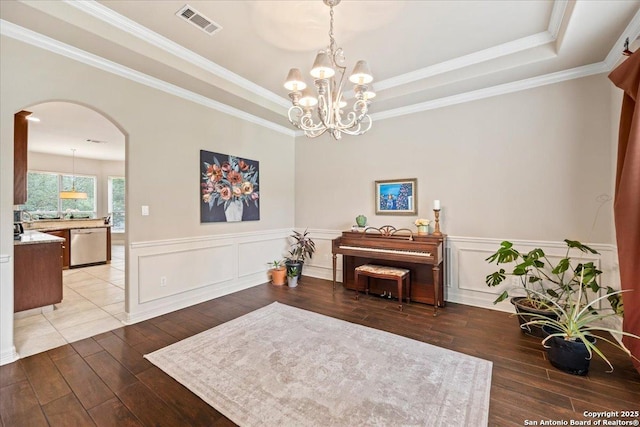 sitting room featuring wood-type flooring, arched walkways, a raised ceiling, and visible vents