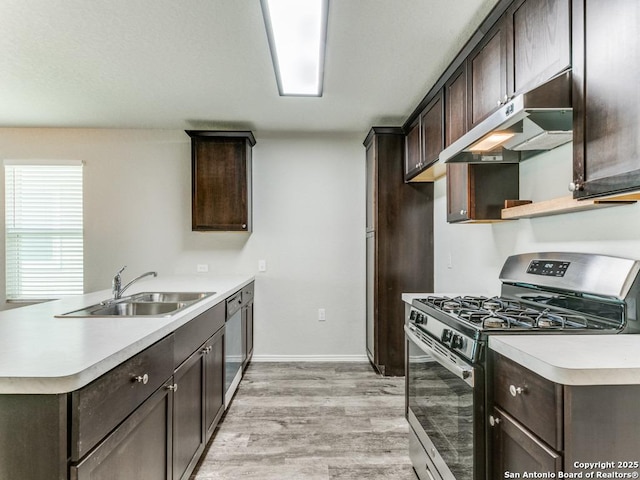 kitchen with a sink, appliances with stainless steel finishes, light wood-type flooring, and dark brown cabinets