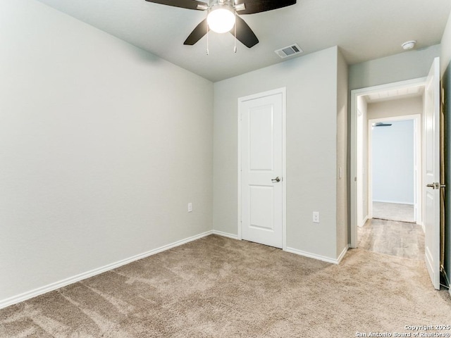 unfurnished bedroom with visible vents, baseboards, ceiling fan, and light carpet