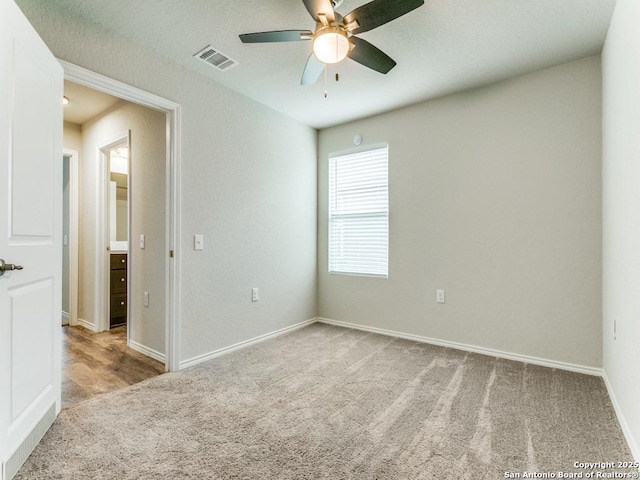 unfurnished room with visible vents, baseboards, carpet floors, and ceiling fan