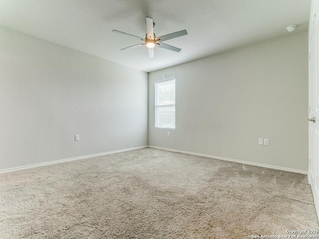 empty room with carpet floors, ceiling fan, and baseboards