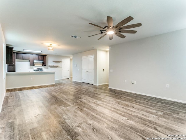unfurnished living room with baseboards, ceiling fan, light wood-style flooring, and visible vents