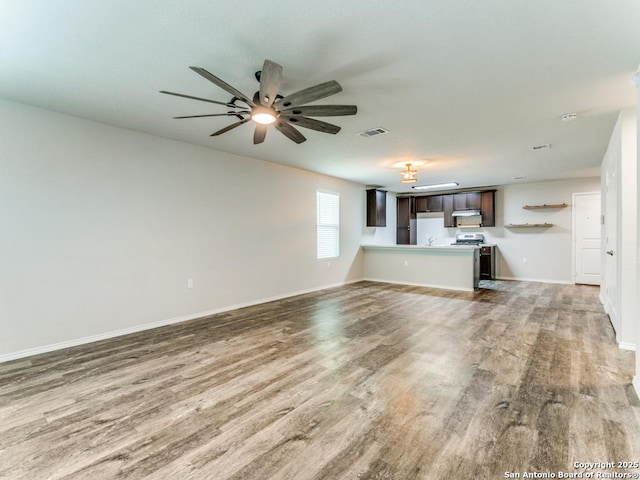 unfurnished living room featuring visible vents, a ceiling fan, baseboards, and wood finished floors