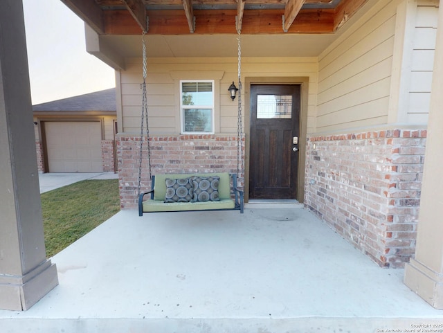 entrance to property featuring covered porch and brick siding