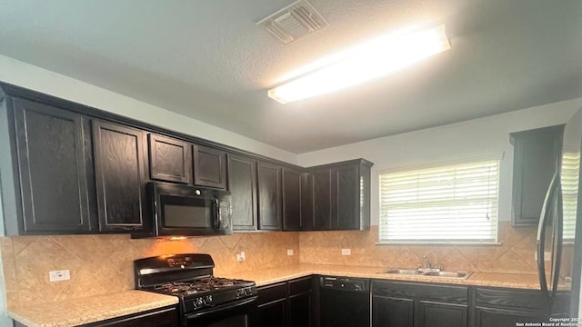 kitchen with backsplash, visible vents, a sink, light countertops, and black appliances