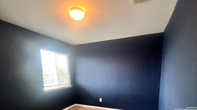 empty room featuring baseboards and visible vents