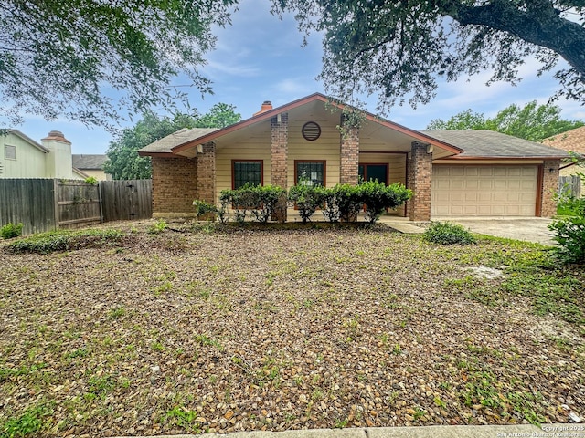 single story home featuring brick siding, a garage, fence, and driveway