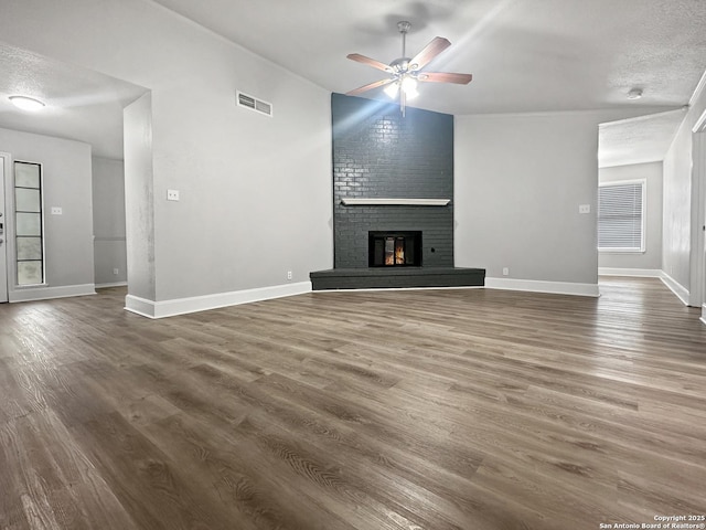 unfurnished living room featuring baseboards, ceiling fan, visible vents, and wood finished floors