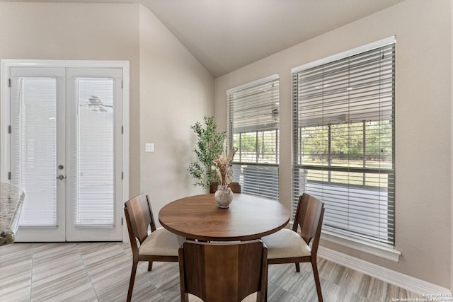 dining area featuring baseboards, french doors, and lofted ceiling