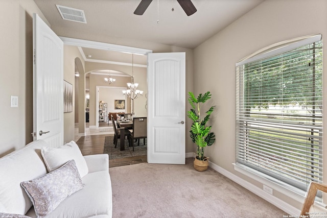 living area featuring visible vents, arched walkways, baseboards, ceiling fan with notable chandelier, and carpet