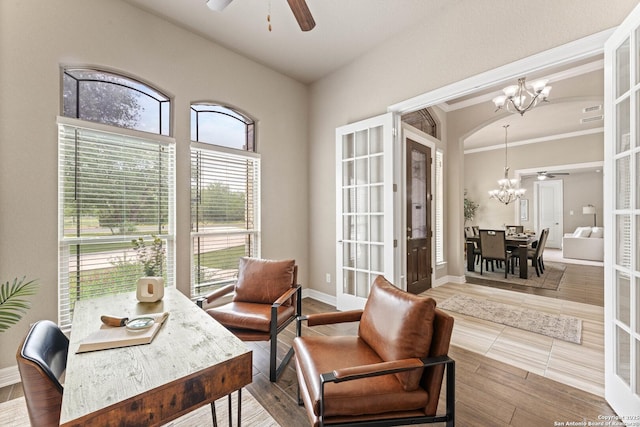 home office with french doors, crown molding, baseboards, and ceiling fan with notable chandelier