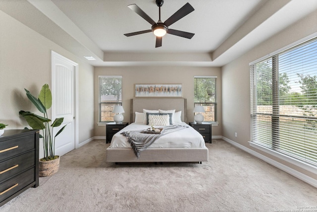 bedroom featuring carpet floors, a ceiling fan, baseboards, and a tray ceiling