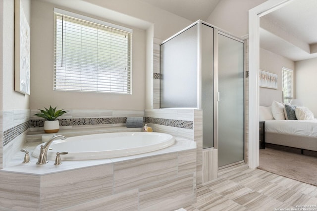 ensuite bathroom featuring ensuite bath, a bath, and a shower stall