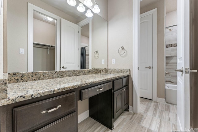 full bath with baseboards and vanity