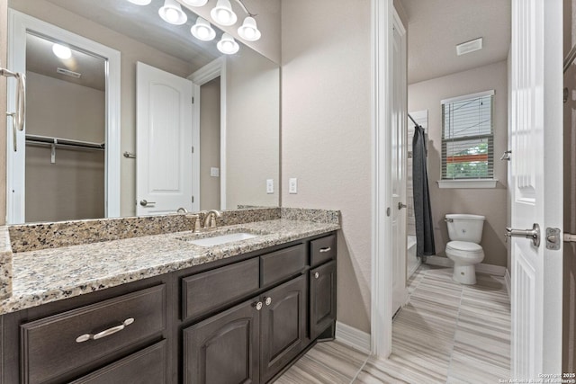 full bathroom with visible vents, vanity, baseboards, toilet, and shower / tub combo with curtain