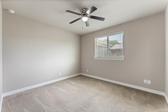 spare room featuring baseboards, ceiling fan, and light colored carpet