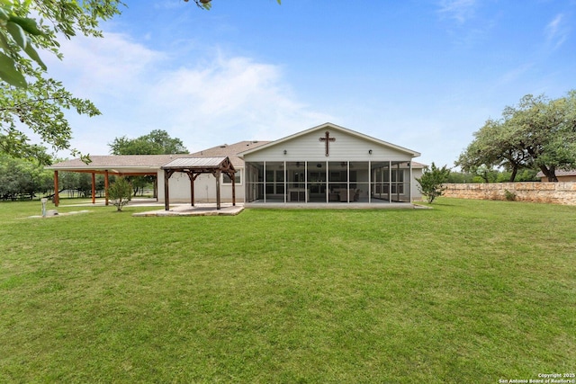 back of house featuring a lawn, a gazebo, and a sunroom
