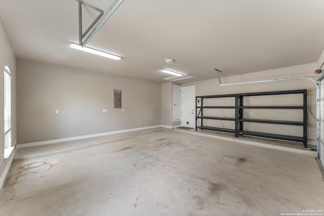 garage with baseboards and electric panel