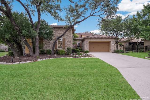 mediterranean / spanish-style house with a garage, a front yard, stone siding, a tiled roof, and concrete driveway