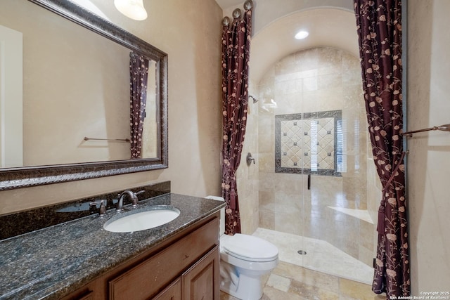 bathroom featuring toilet, a shower stall, and vanity