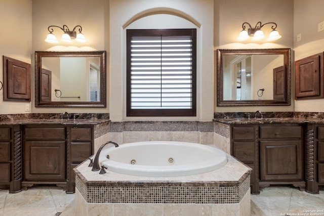 full bath with a jetted tub, a sink, and two vanities