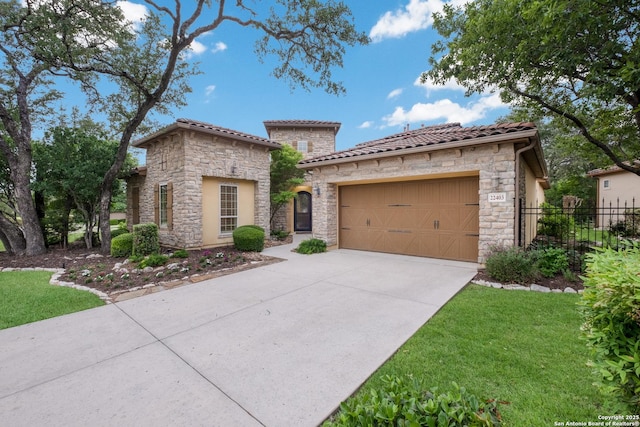 mediterranean / spanish-style home with a tiled roof, driveway, a garage, fence, and stone siding