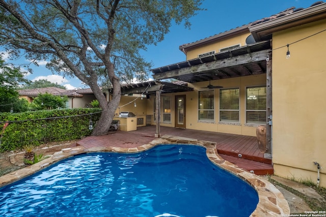 view of swimming pool with fence, a ceiling fan, a wooden deck, and a fenced in pool