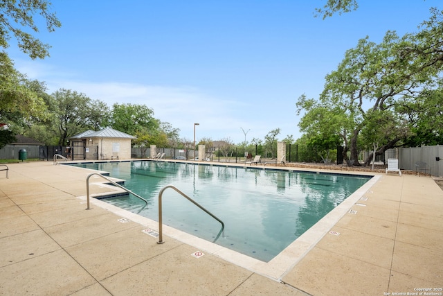 community pool featuring fence and a patio