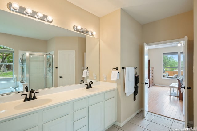 full bath with tile patterned flooring, a sink, a stall shower, and double vanity