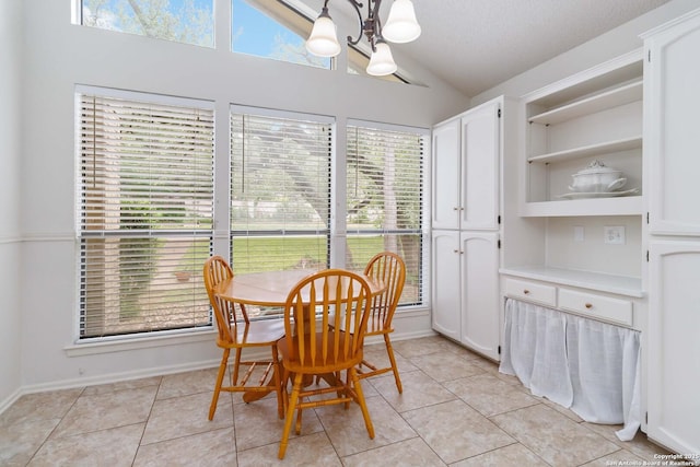 dining space with plenty of natural light, light tile patterned flooring, lofted ceiling, and a notable chandelier