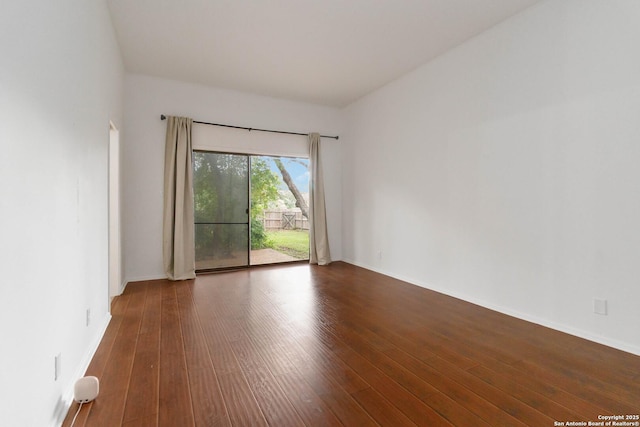 unfurnished room with baseboards and wood finished floors