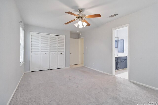 unfurnished bedroom featuring visible vents, baseboards, a closet, and light carpet