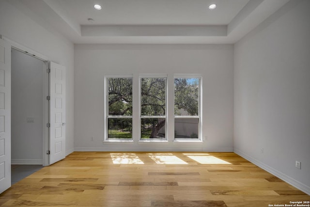 22932 Estacado, San Antonio, TX 78261 - unfurnished room featuring light wood-style floors, a tray ceiling, baseboards, and recessed lighting