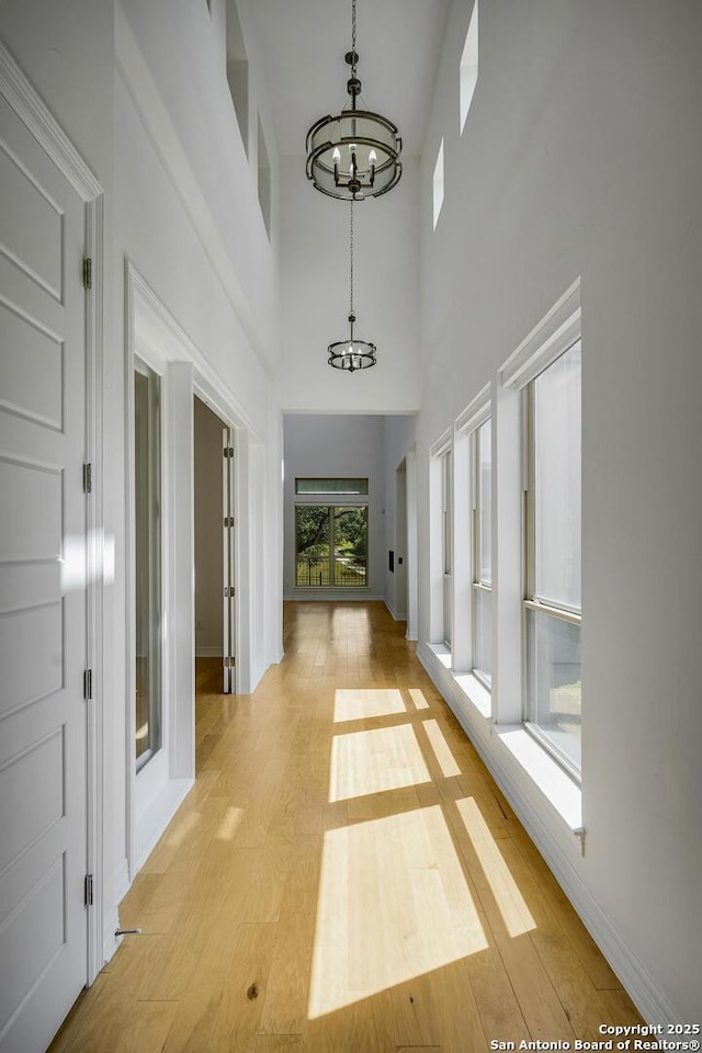 22932 Estacado, San Antonio, TX 78261 - corridor featuring a chandelier, light wood finished floors, baseboards, and a high ceiling
