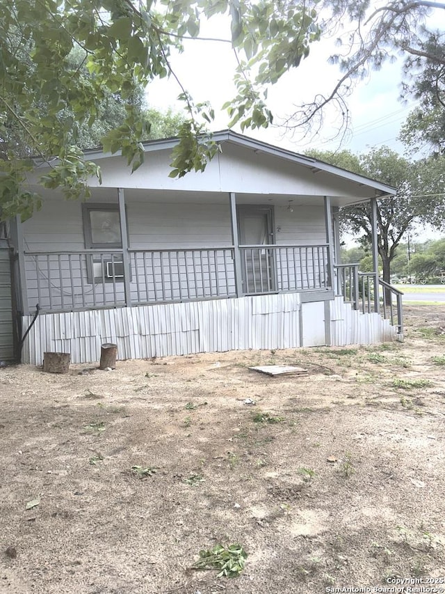 view of side of property featuring covered porch
