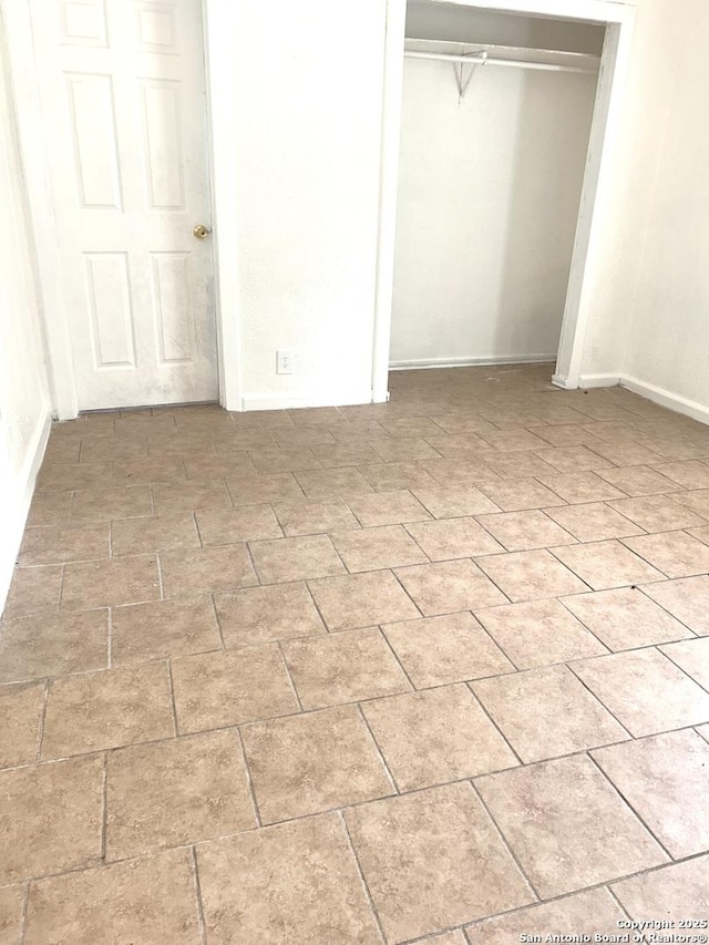 unfurnished bedroom with a closet and brick patterned floor