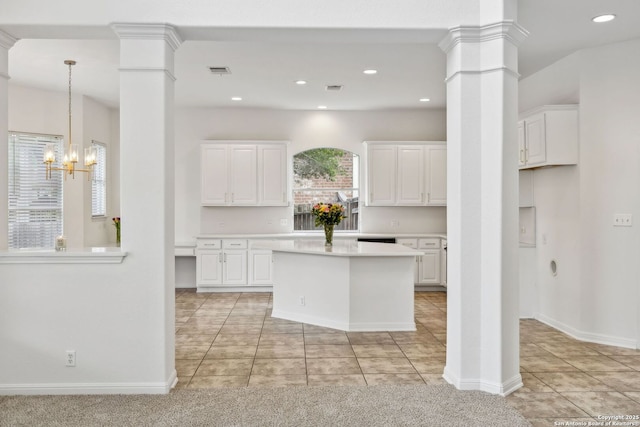 kitchen featuring light countertops, light tile patterned floors, decorative columns, and white cabinetry