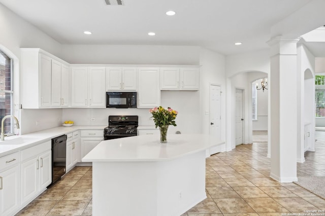 kitchen featuring white cabinets, a sink, arched walkways, a kitchen island, and black appliances