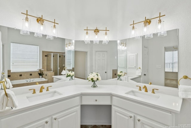bathroom featuring double vanity, a sink, a bath, and a stall shower