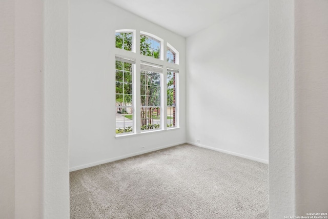 spare room featuring baseboards and carpet