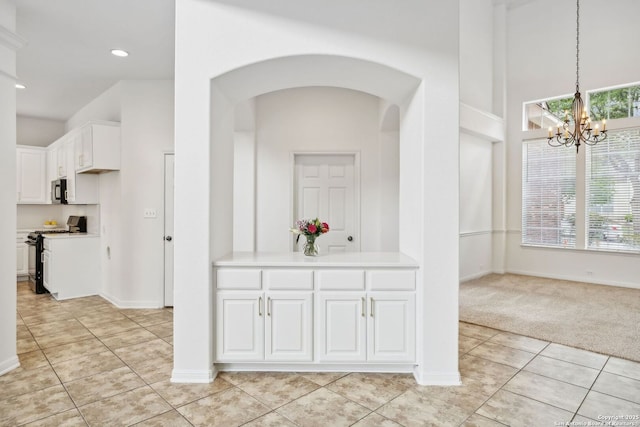 corridor featuring light carpet, baseboards, arched walkways, light tile patterned floors, and a notable chandelier