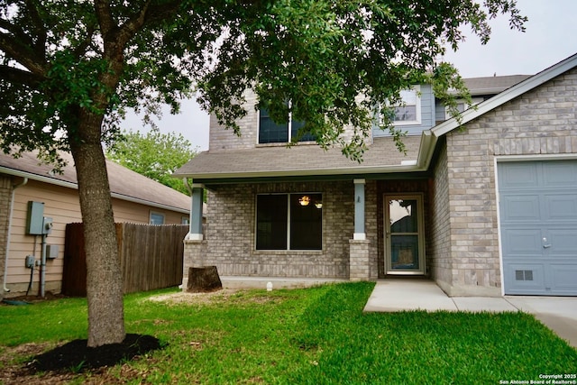 view of front of property featuring fence, brick siding, a front lawn, and a garage