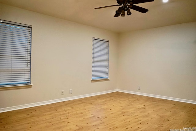 unfurnished room with baseboards, a ceiling fan, and wood finished floors