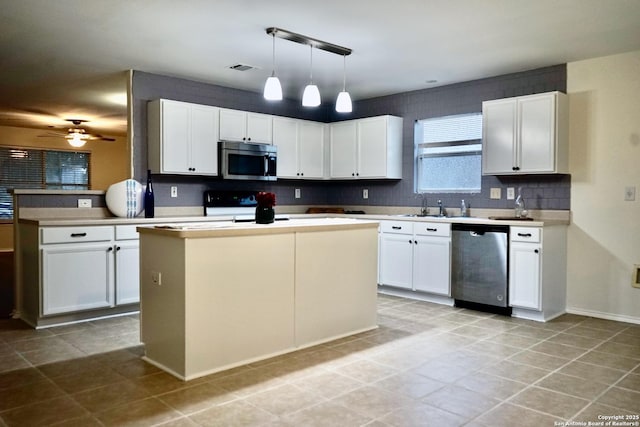 kitchen featuring ceiling fan, backsplash, hanging light fixtures, white cabinets, and stainless steel appliances